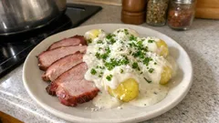 Uzené maso s bramborovým salátem a pažitkou na talíři