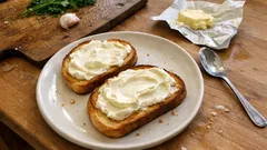 Otevřený sendvič s tvarohovou pomazánkou na talíři