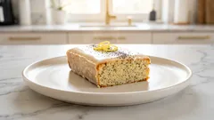 Makovo-citronový řez s polevou na bílém talíři v kuchyni