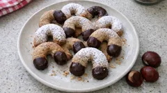 Vanilkové rohlíčky posypané cukrem na talíři s kaštany