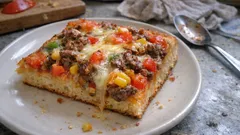 Domácí pizza s rajčaty, kukuricí, houbami a sýrem na talíři