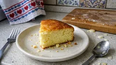 Plátek domácího koláče na talíři s vidličkou a lžící