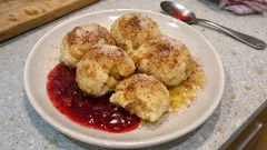 Domácí kynuté knedlíky se švestkovou omáčkou na talíři